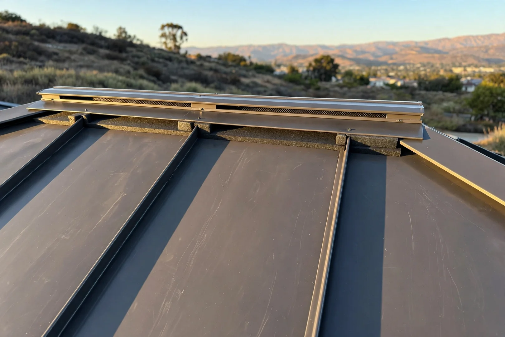 Ridge vent and cap flashing detail completed on a metal roof assembly